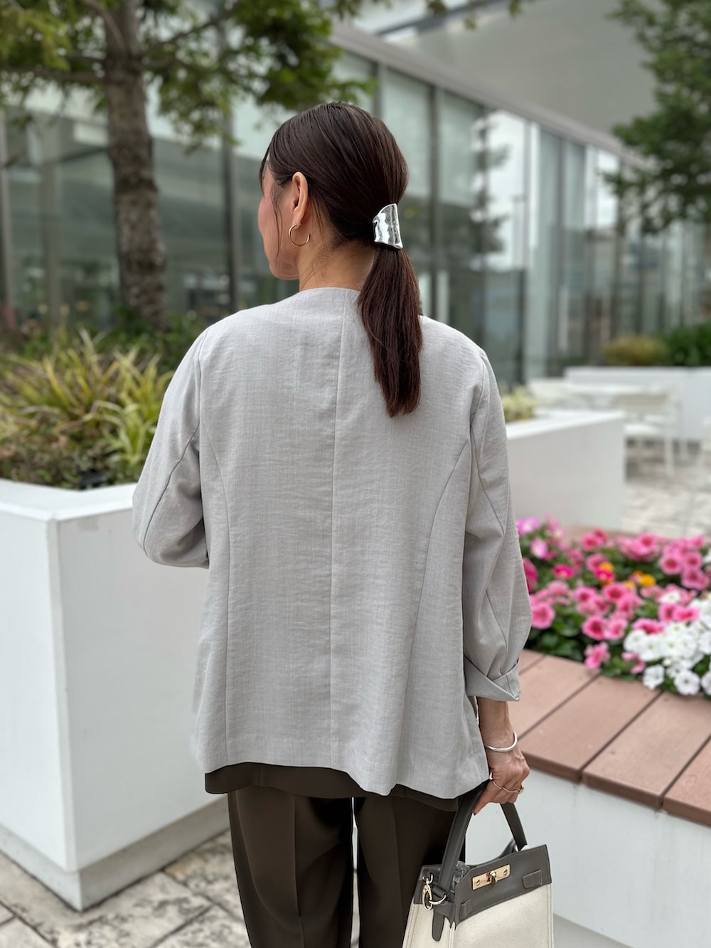 ベージュ系のダウンジャケット/コート、ブルー系のシャツ/ブラウス、ホワイト系のTシャツ/カットソーを着用したレディースの夏コーディネートの6枚目の写真