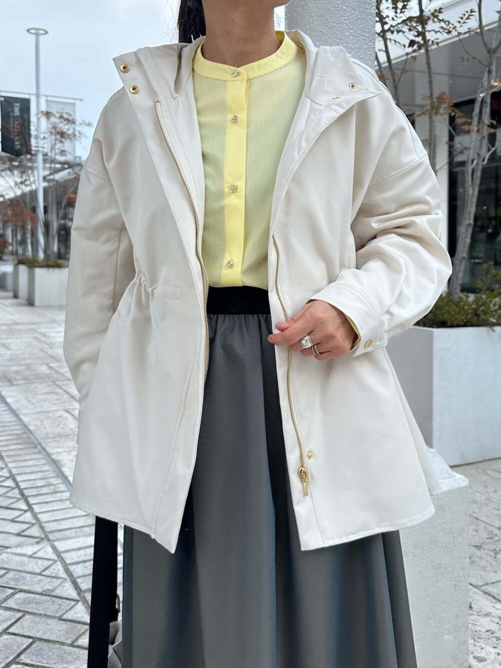 ホワイト系のブルゾン、イエロー系のシャツ/ブラウス、グリーン系のスカートを着用したレディースの冬コーディネートの5枚目の写真