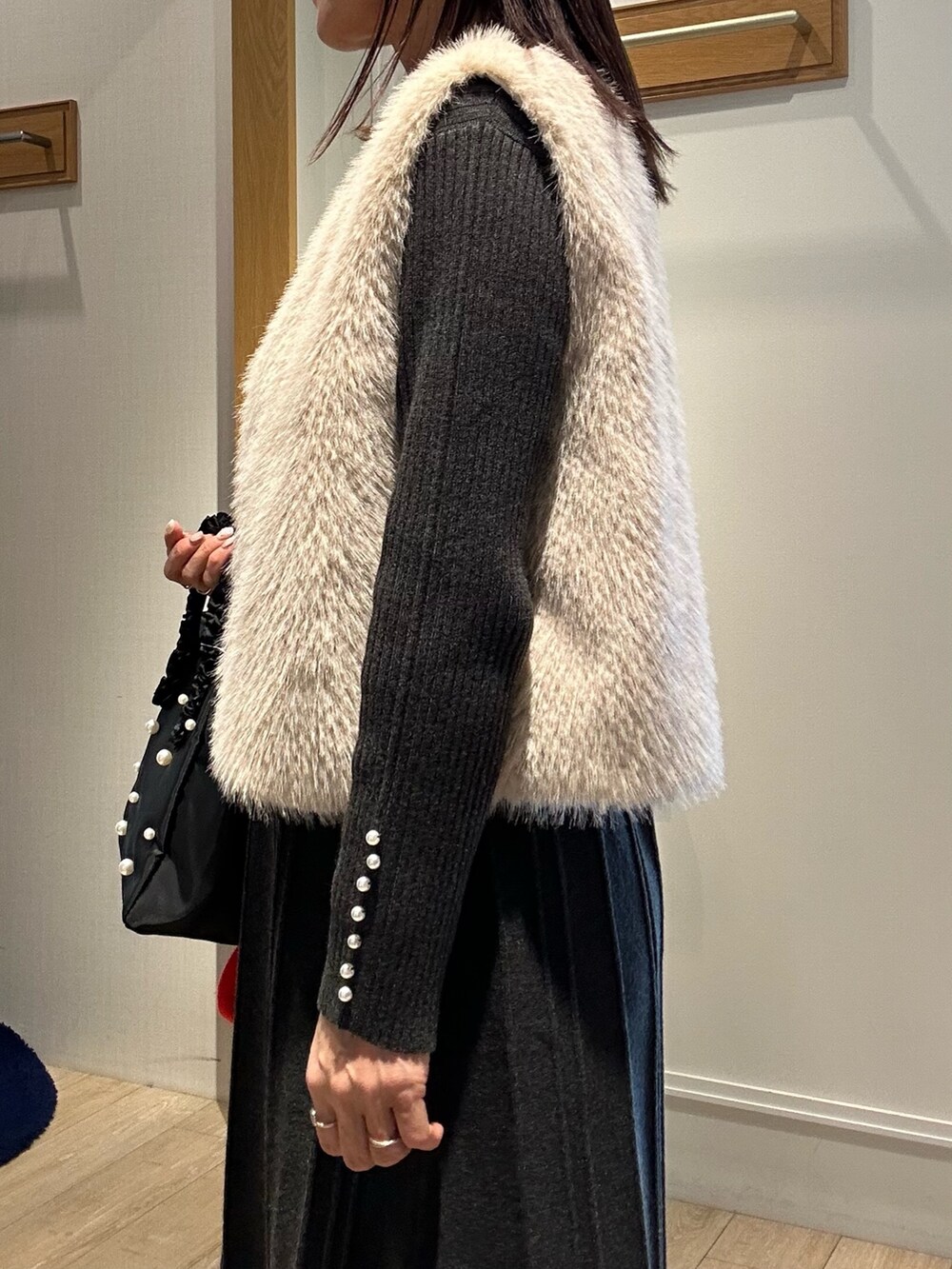 ベージュ系のブルゾン、グレー系のワンピース、ブラック系のダウンジャケット/コートを着用したレディースの冬コーディネートの5枚目の写真