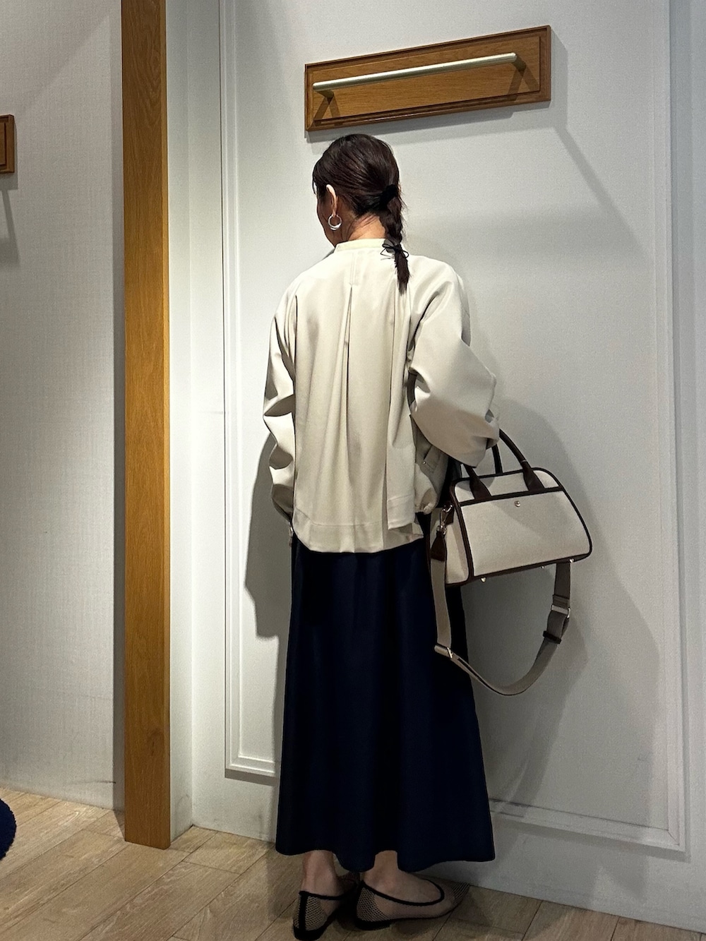 イエロー系のシャツ/ブラウス、ホワイト系のブルゾン、ブルー系のスカートを着用したレディースの冬コーディネートの4枚目の写真