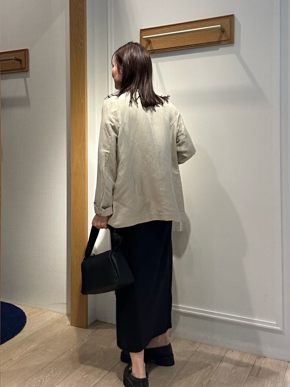 ベージュ系のテーラードジャケット、グリーン系のシャツ/ブラウス、ブラック系のスカートを着用したレディースの春コーディネートの3枚目の写真