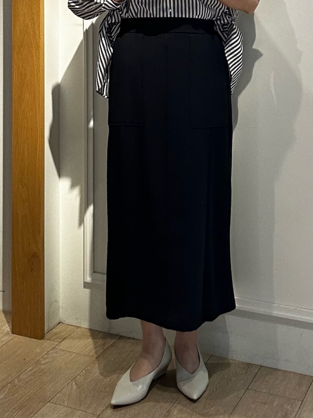 ブラック系のスカート、グレー系のシャツ/ブラウスを着用したレディースの春コーディネートの7枚目の写真