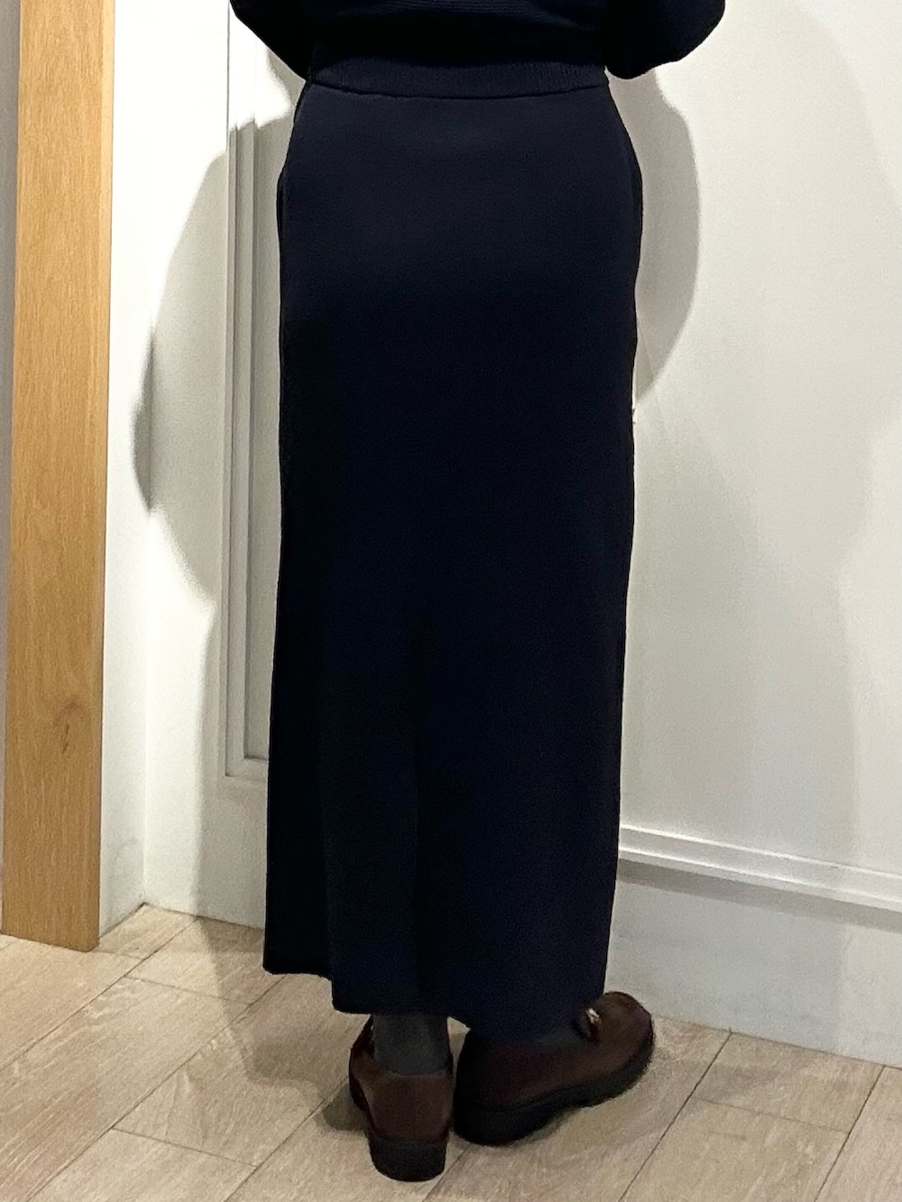 ホワイト系のトートバッグ、ブラウン系のローファー、ブルー系のニット/セーターを着用したレディースの冬コーディネートの8枚目の写真