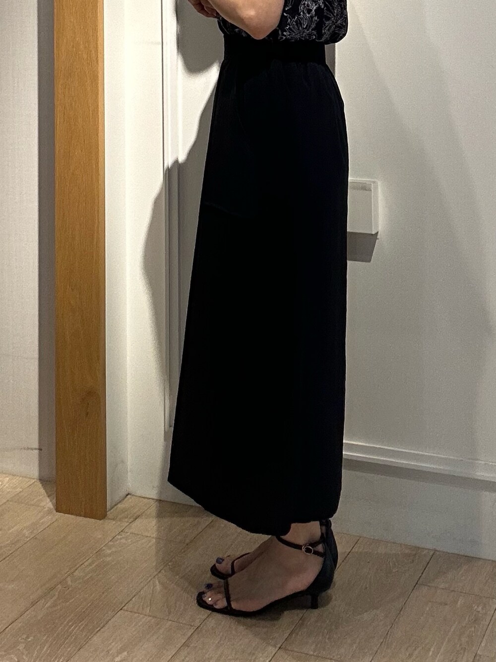 ブラック系のシャツ/ブラウス、ブラック系のスカート、ベージュ系のノーカラージャケットを着用したレディースの夏コーディネートの8枚目の写真