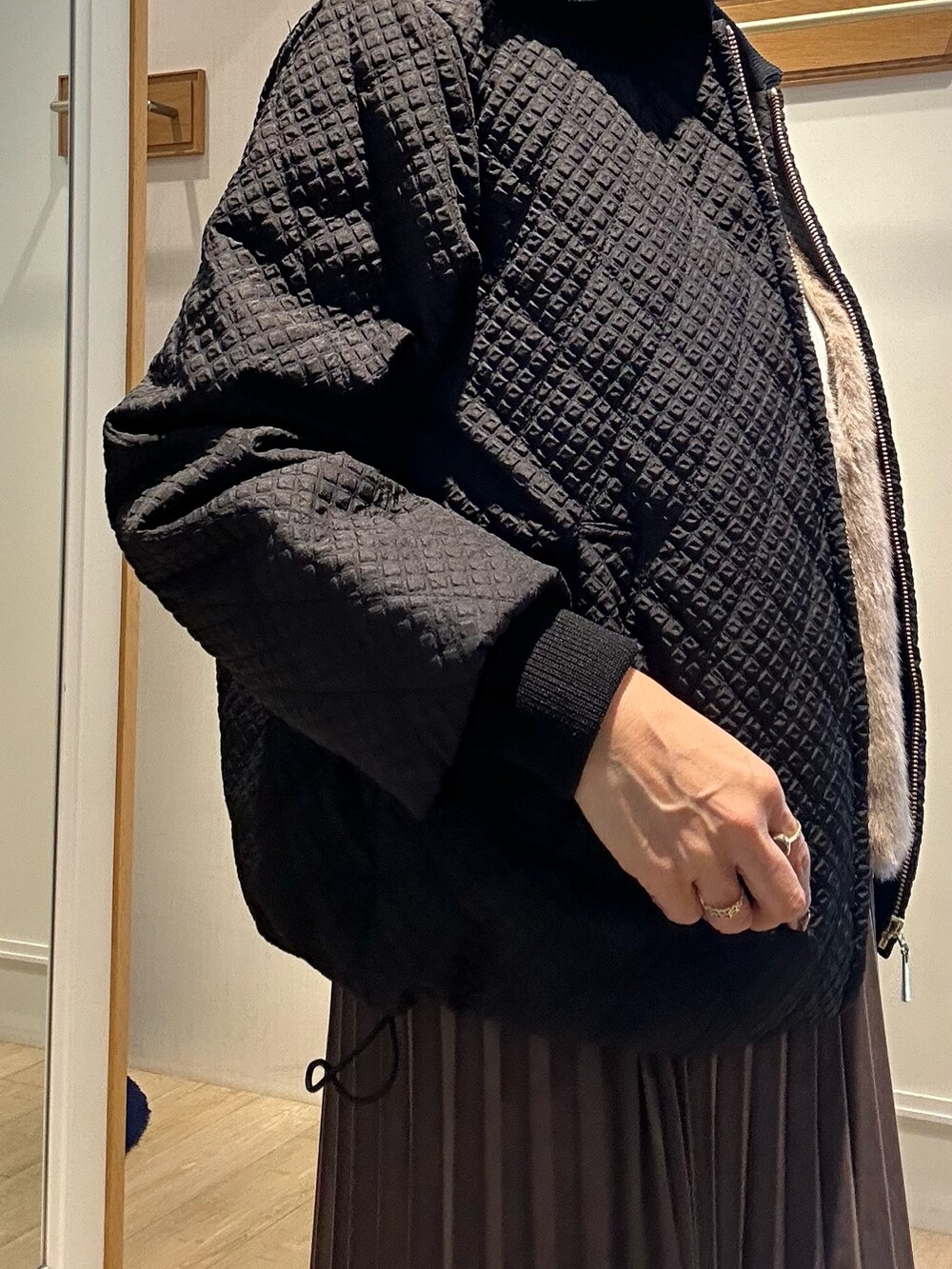 ブラウン系のブルゾン、ホワイト系のニット/セーター、ブラウン系のスカートを着用したレディースの秋コーディネートの6枚目の写真