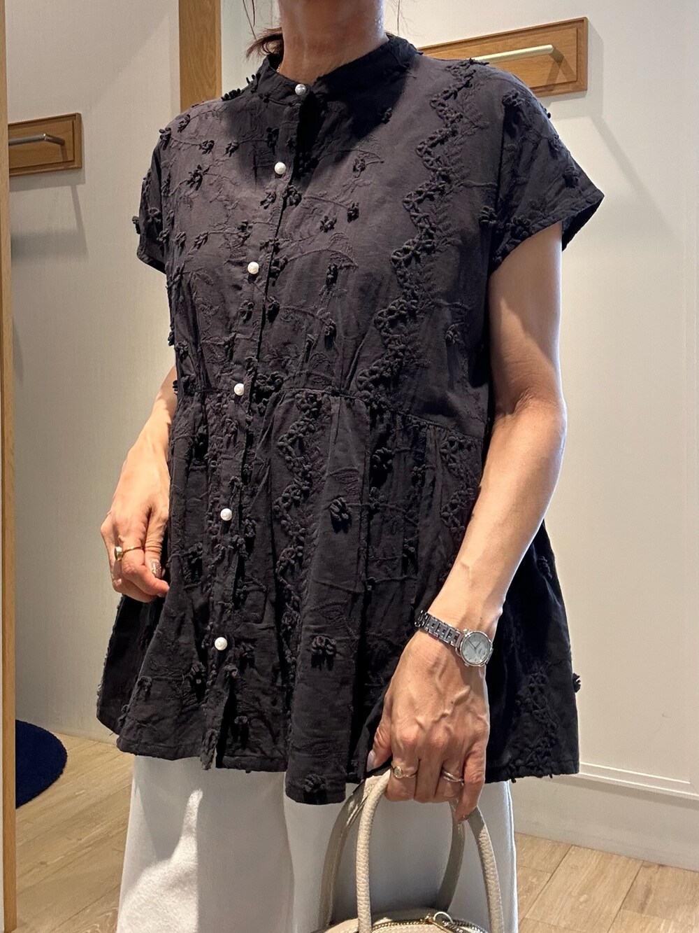 ブラック系のシャツ/ブラウス、ホワイト系のデニムパンツ、ベージュ系のボストンバッグを着用したレディースの夏コーディネートの7枚目の写真