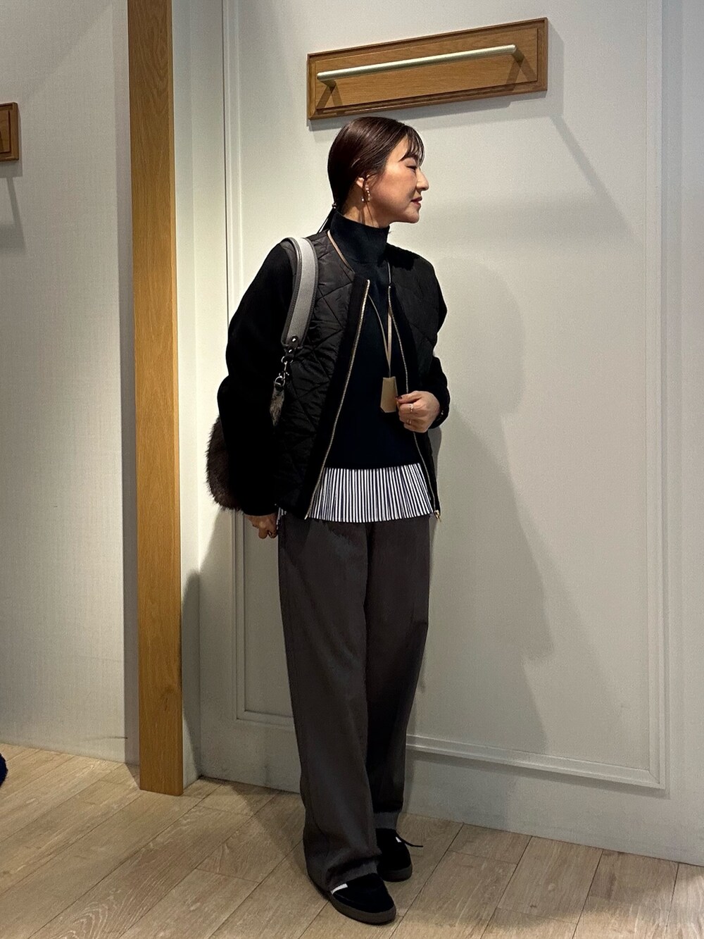 ブラック系のブルゾン、グレー系のその他パンツ、ブラック系のニット/セーターを着用したレディースの秋コーディネートの9枚目の写真