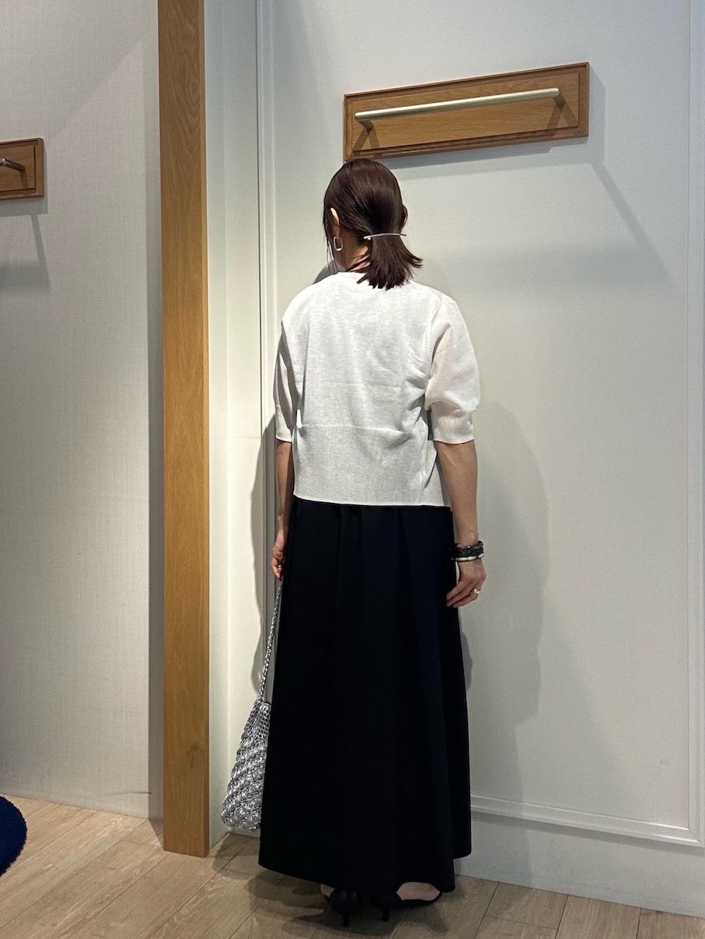 ホワイト系のニット/セーター、ブラック系のワンピース、ブラック系のサンダルを着用したレディースの夏コーディネートの3枚目の写真