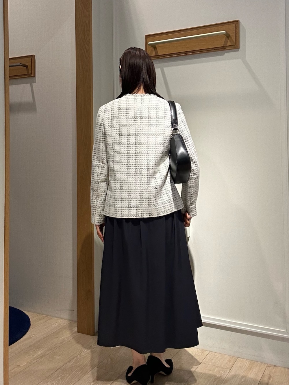 ホワイト系のノーカラージャケット、ブルー系のスカートを着用したレディースの冬コーディネートの2枚目の写真