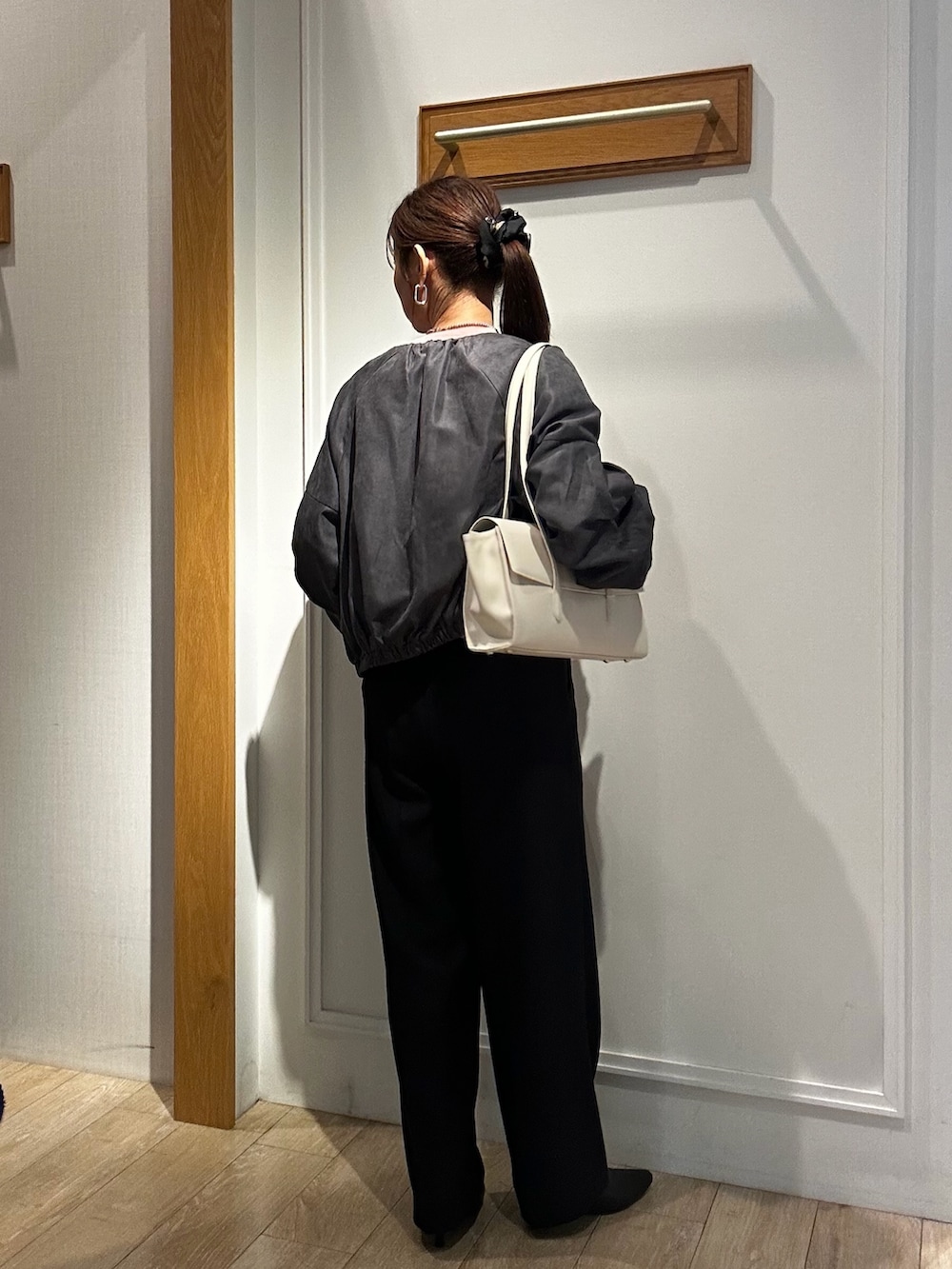 ブラック系のショルダーバッグ、ブラック系のその他パンツ、グレー系のブルゾンを着用したレディースの秋コーディネートの2枚目の写真