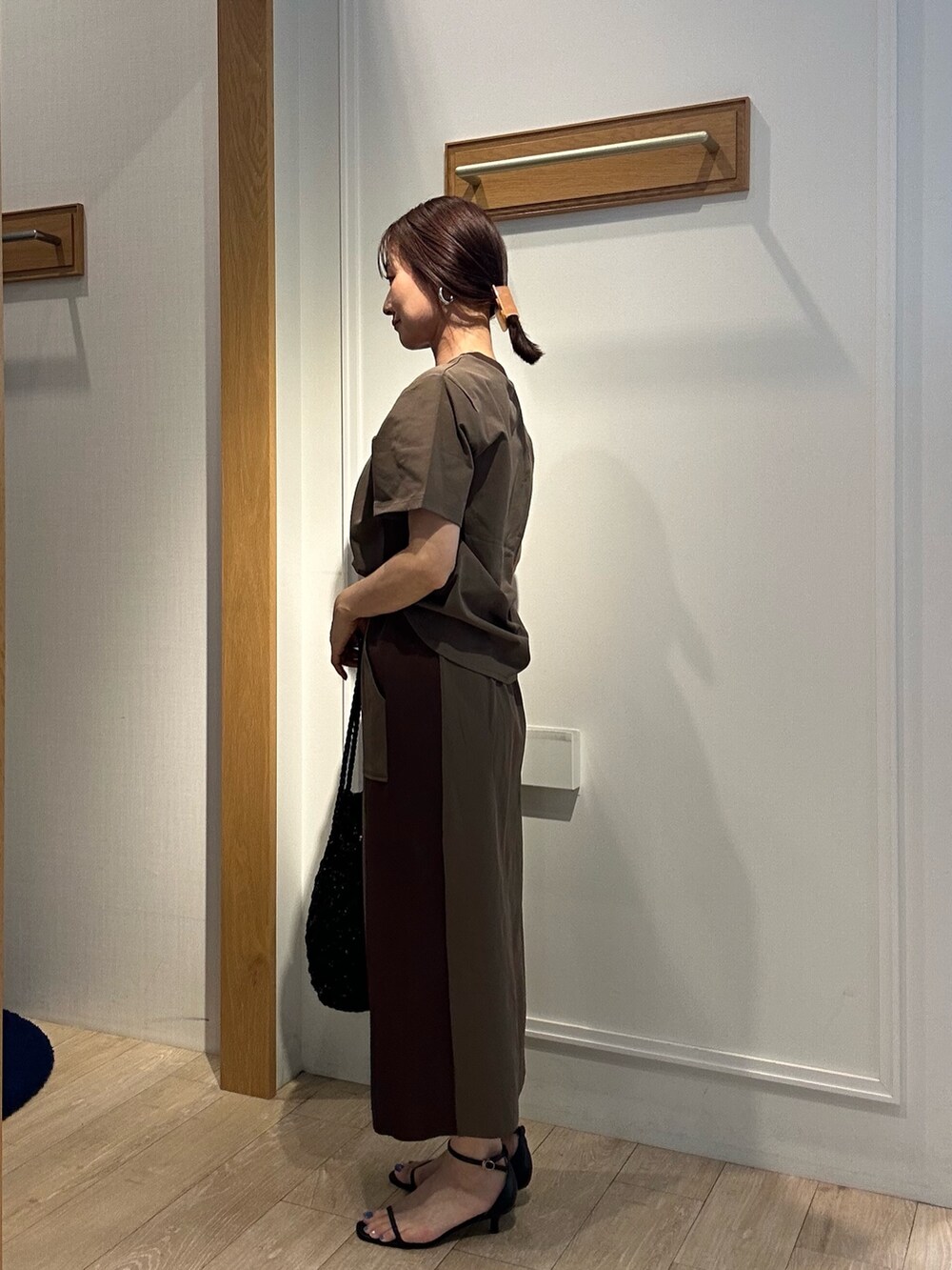 ブラウン系のTシャツ/カットソー、ブラウン系のスカート、ブラック系のサンダルを着用したレディースの夏コーディネートの2枚目の写真