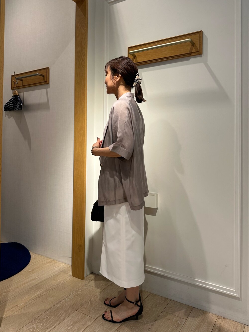 ブラック系のサンダル、グレー系のTシャツ/カットソー、ホワイト系のスカートを着用したレディースの夏コーディネートの3枚目の写真