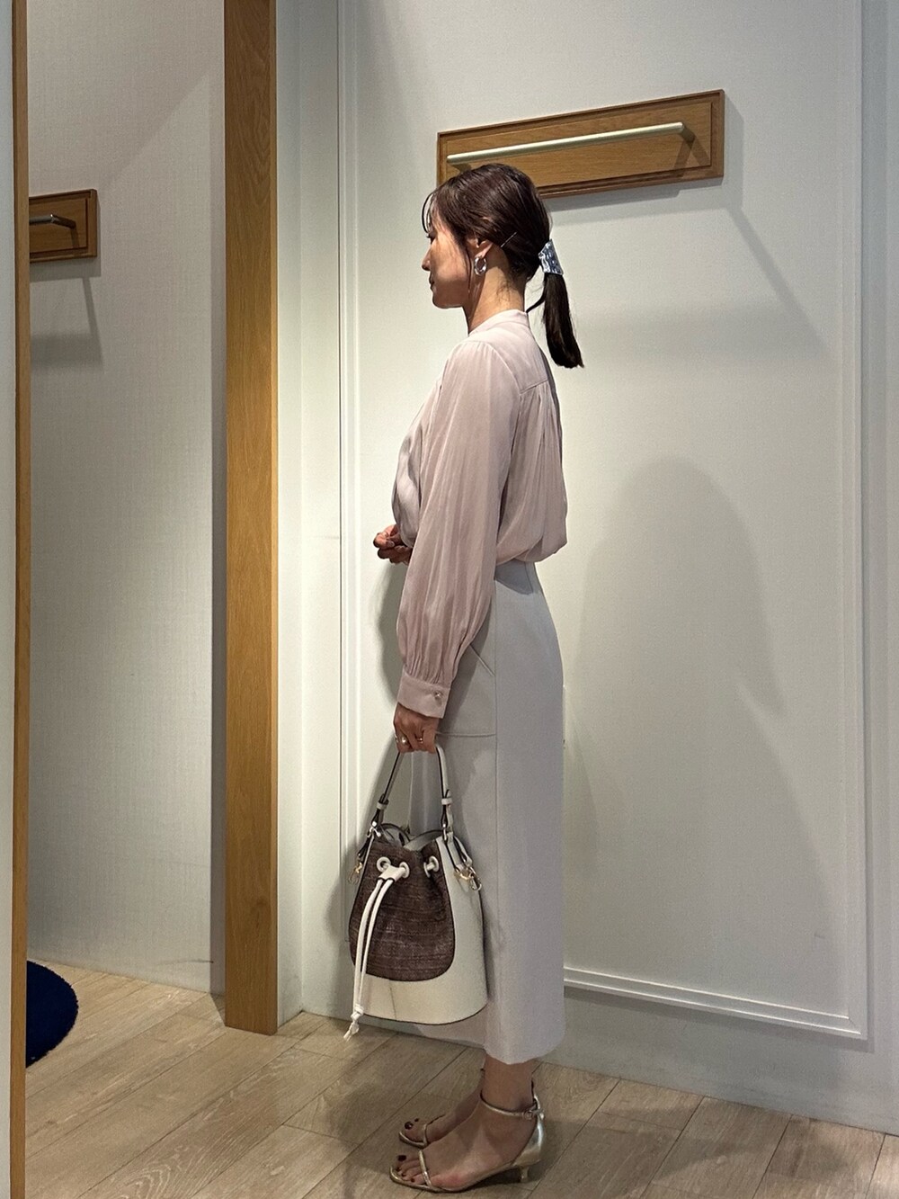 ピンク系のシャツ/ブラウス、ベージュ系のスカートを着用したレディースの春コーディネートの2枚目の写真