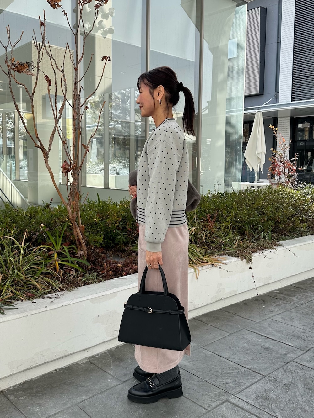 グレー系のブルゾン、グレー系のニット/セーター、ピンク系のスカートを着用したレディースの冬コーディネートの8枚目の写真