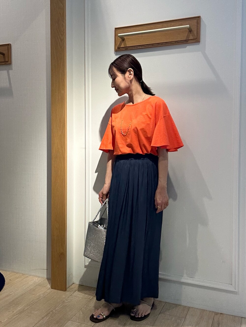 オレンジ系のTシャツ/カットソー、ブルー系のその他パンツを着用したレディースの夏コーディネートの2枚目の写真