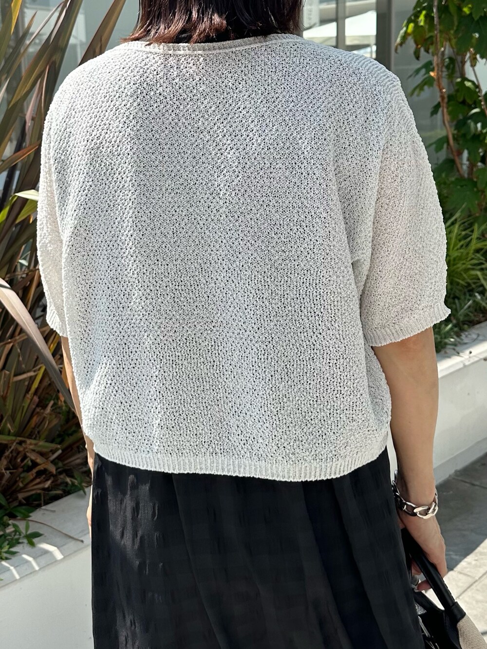 ブラック系のワンピース、ブラック系のサンダル、ホワイト系のカーディガン/ボレロを着用したレディースの夏コーディネートの10枚目の写真