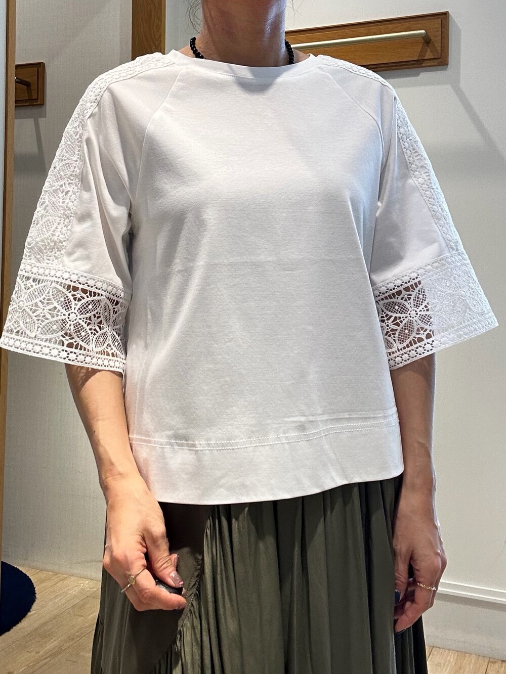 ホワイト系のTシャツ/カットソー、ブラック系のトートバッグ、グリーン系のスカートを着用したレディースの夏コーディネートの5枚目の写真