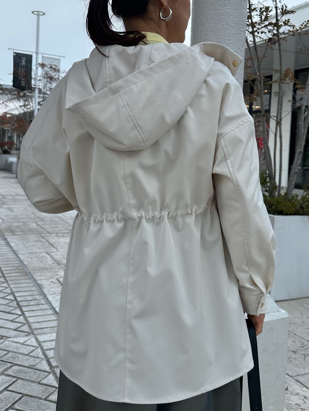 ホワイト系のブルゾン、イエロー系のシャツ/ブラウス、グリーン系のスカートを着用したレディースの冬コーディネートの8枚目の写真