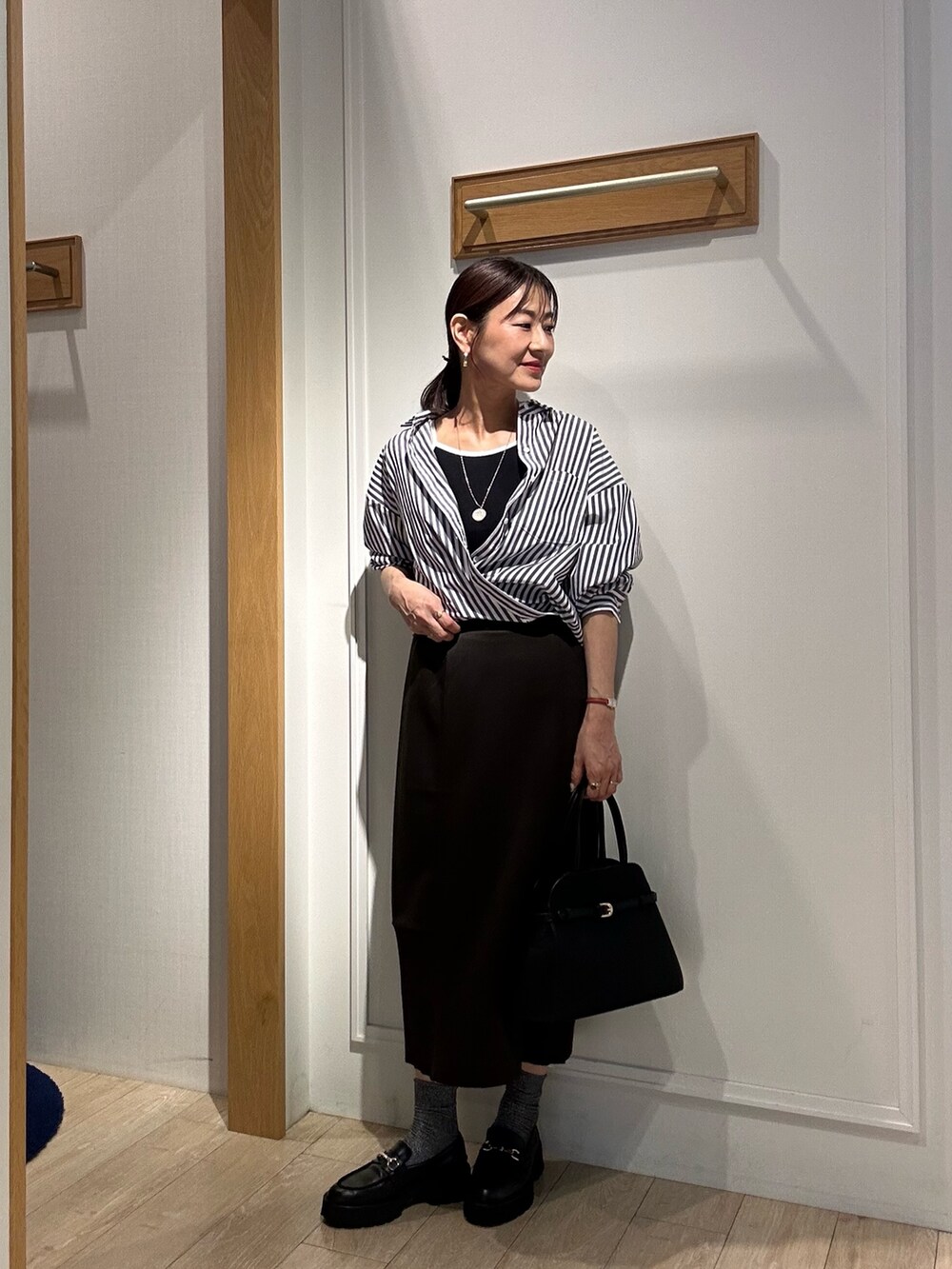 ブラック系のシャツ/ブラウス、ブラウン系のスカート、ブラック系のキャミソールを着用したレディースの秋コーディネートの6枚目の写真