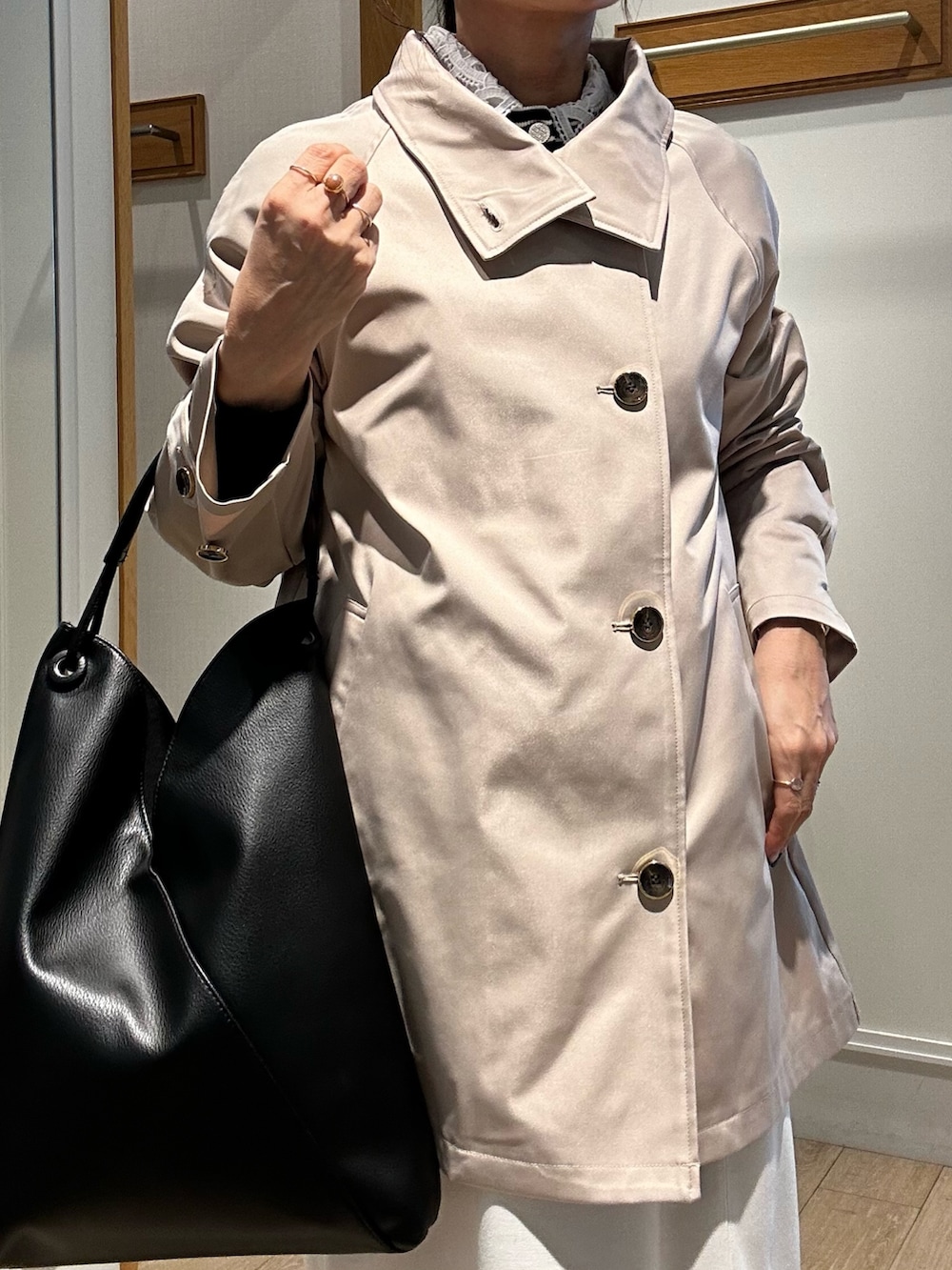 ベージュ系のその他アウター、ブラック系のニット/セーター、ホワイト系のスカートを着用したレディースの冬コーディネートの10枚目の写真