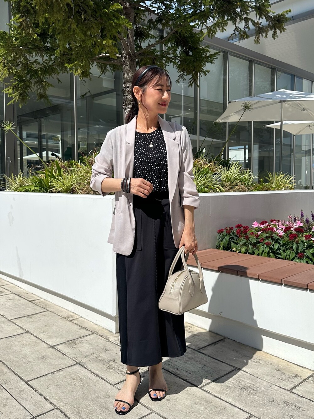 ブラック系のシャツ/ブラウス、ブラック系のスカート、ベージュ系のボストンバッグを着用したレディースの夏コーディネートの8枚目の写真