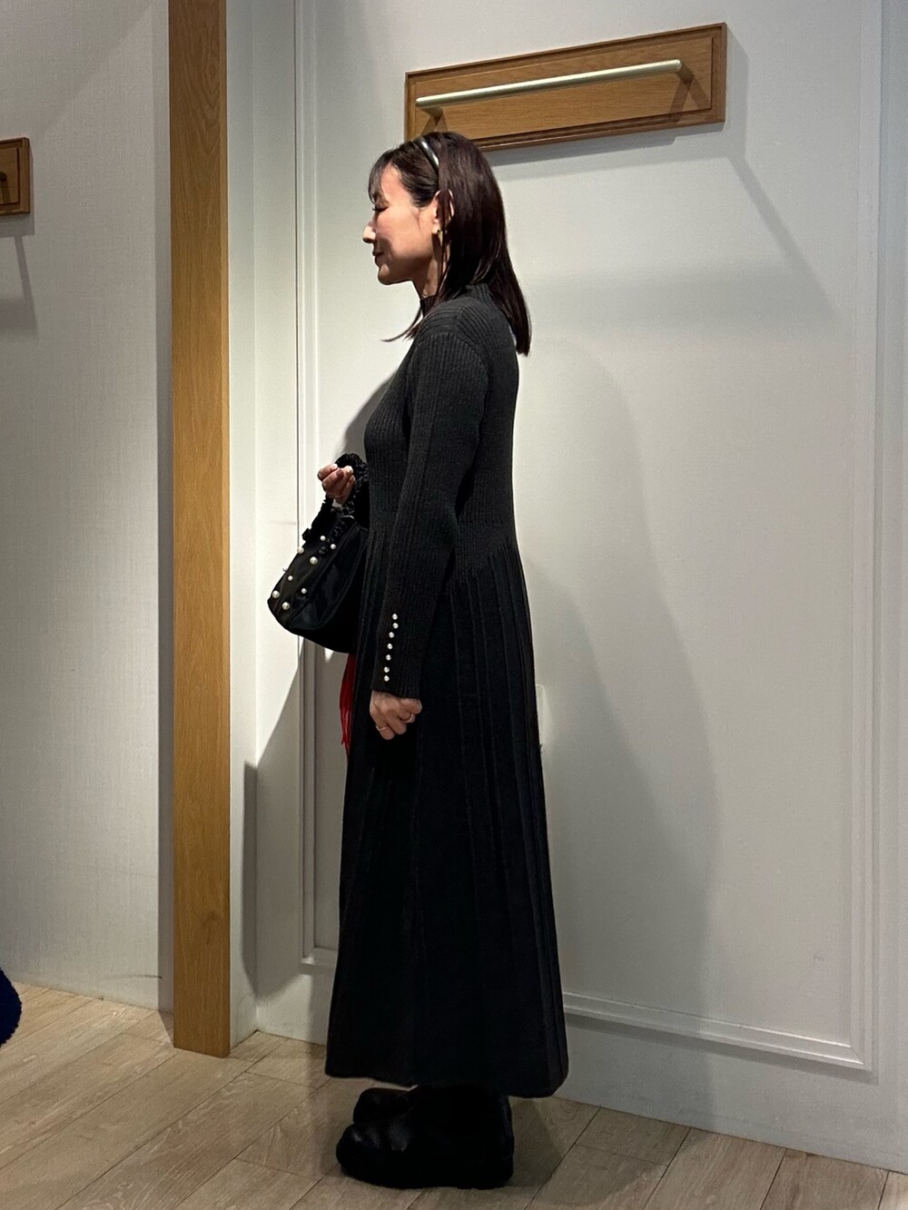 グレー系のワンピース、ブラック系のダウンジャケット/コート、ベージュ系のブルゾンを着用したレディースの冬コーディネートの2枚目の写真