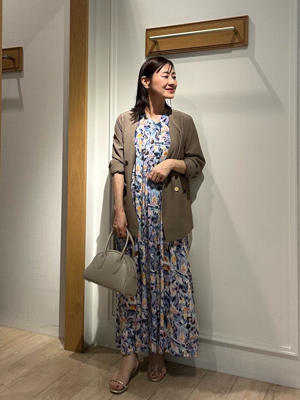 ブルー系のワンピース、イエロー系のノーカラージャケット、ベージュ系のボストンバッグを着用したレディースの夏コーディネートの6枚目の写真
