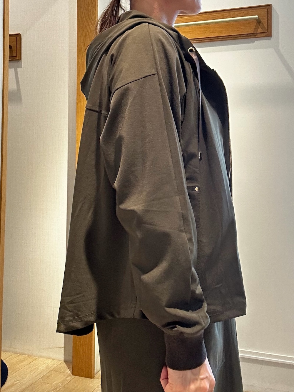 グリーン系のブルゾン、ベージュ系のTシャツ/カットソー、ブラック系のトートバッグを着用したレディースの秋コーディネートの6枚目の写真