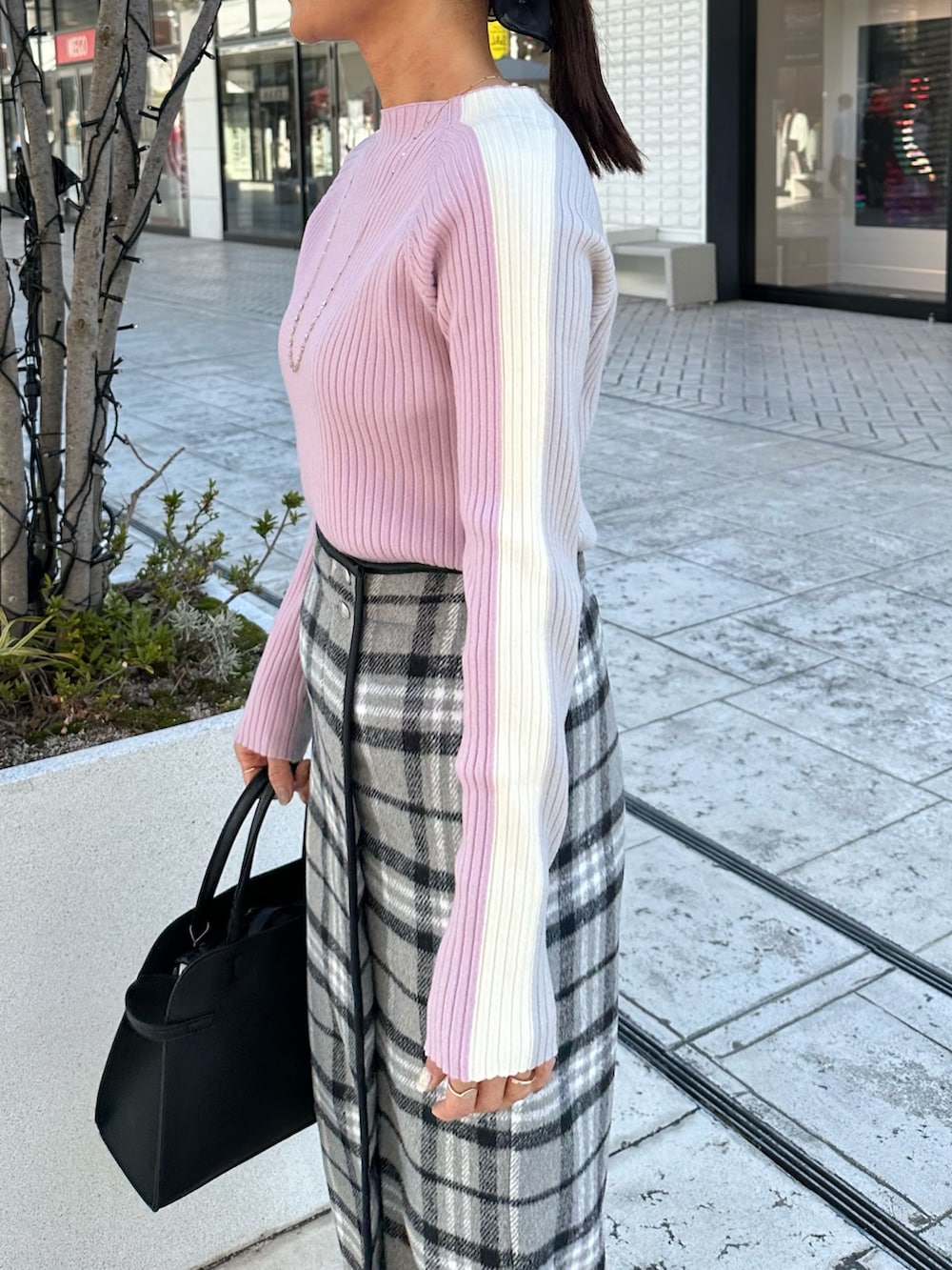 グレー系のスカート、ブラック系のトートバッグ、ピンク系のニット/セーターを着用したレディースの秋コーディネートの6枚目の写真