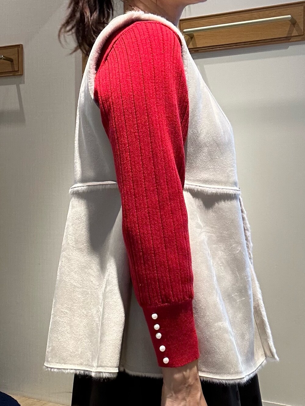 レッド系のニット/セーター、ブラウン系のスカート、ブラック系のトートバッグを着用したレディースの秋コーディネートの9枚目の写真