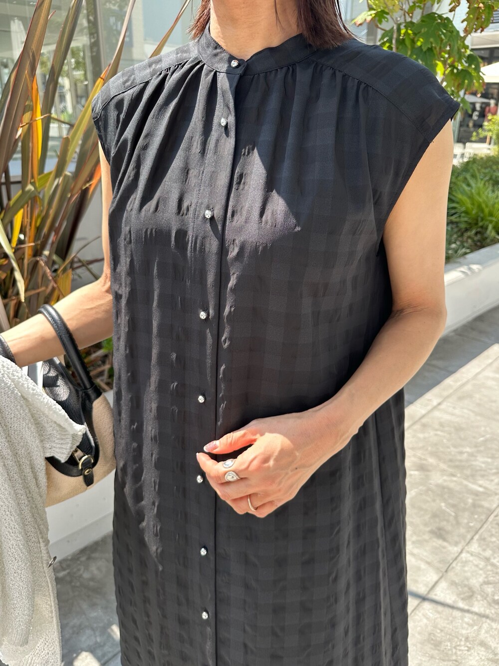 ブラック系のワンピース、ホワイト系のカーディガン/ボレロ、ブラック系のバックパック/リュックを着用したレディースの夏コーディネートの10枚目の写真