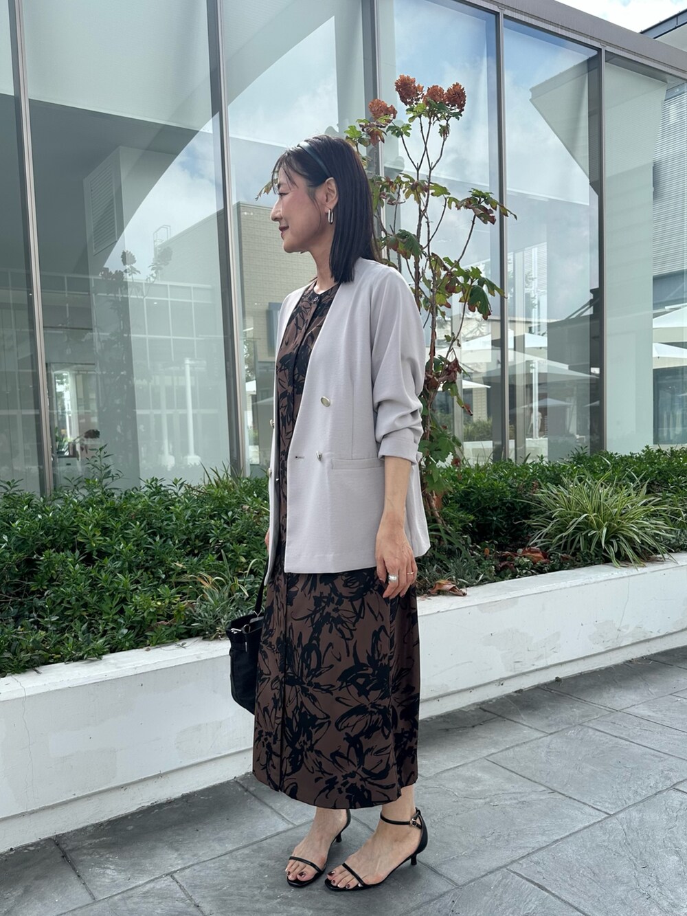 ベージュ系のワンピース、ブラック系のトートバッグ、ベージュ系のノーカラージャケットを着用したレディースの秋コーディネートの7枚目の写真