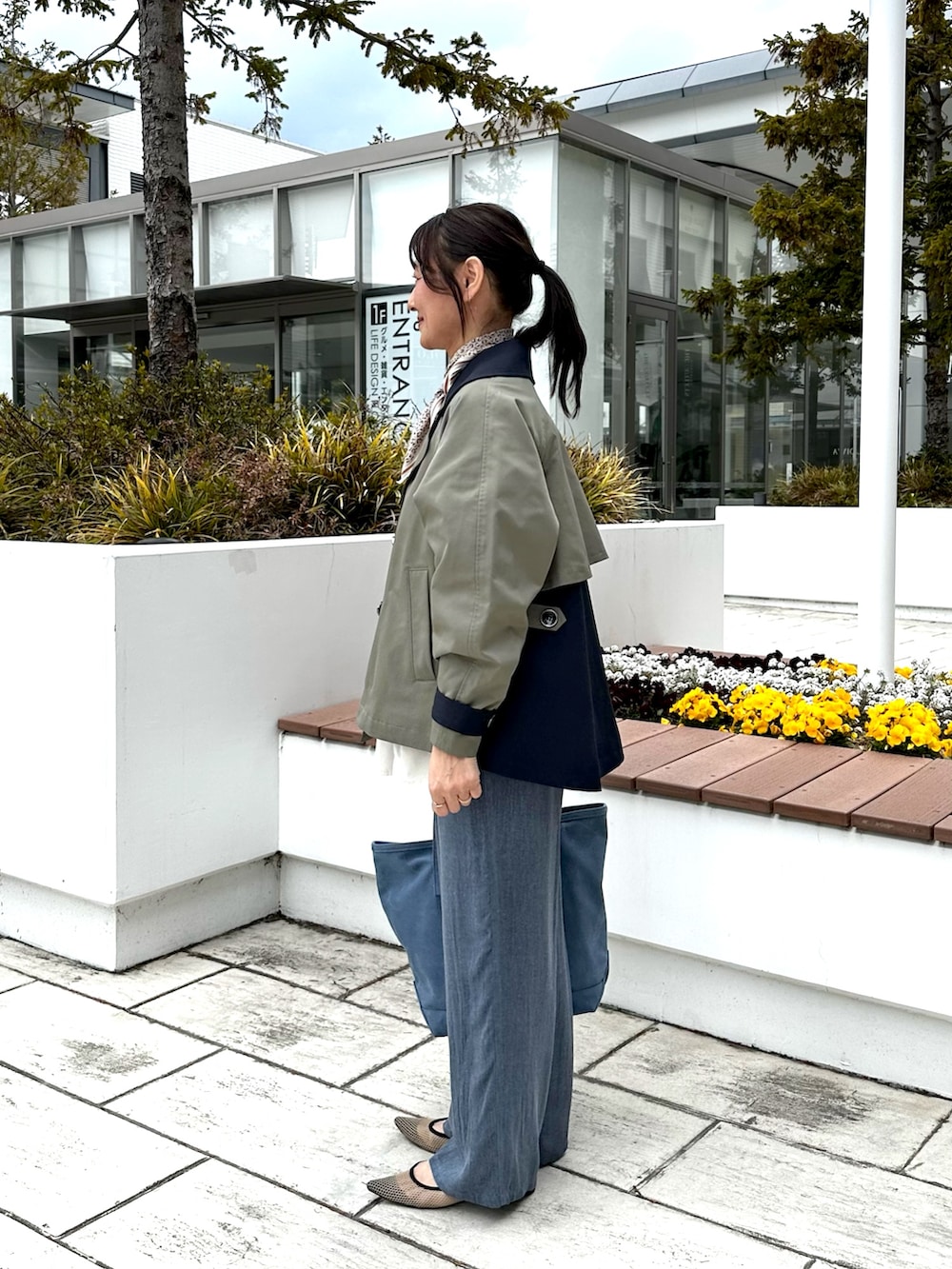 ブルー系のその他パンツ、ブルー系のトートバッグ、ホワイト系のシャツ/ブラウスを着用したレディースの春コーディネートの2枚目の写真