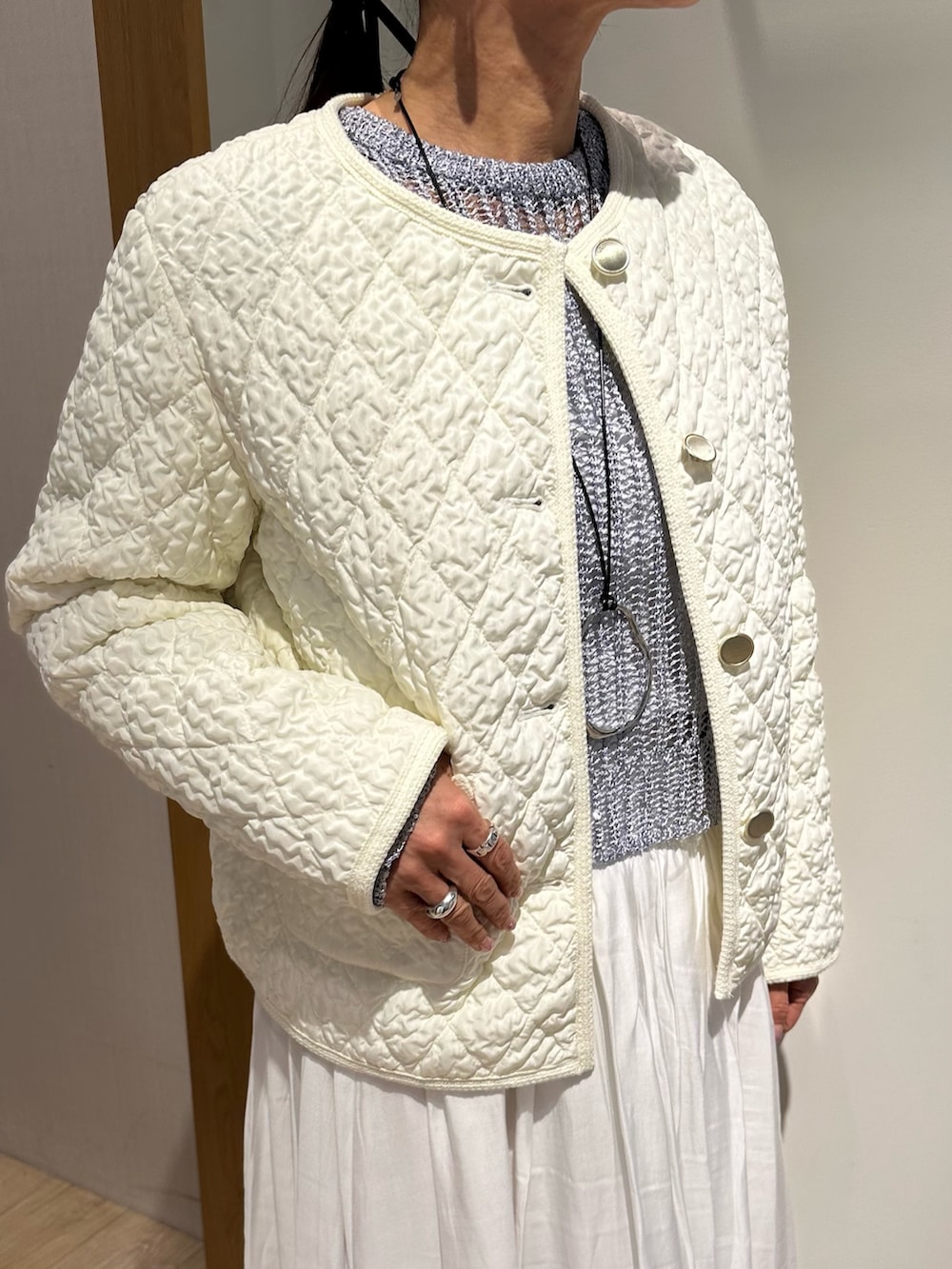 ホワイト系のブルゾン、ブルー系のニット/セーター、ホワイト系のスカートを着用したレディースの冬コーディネートの4枚目の写真