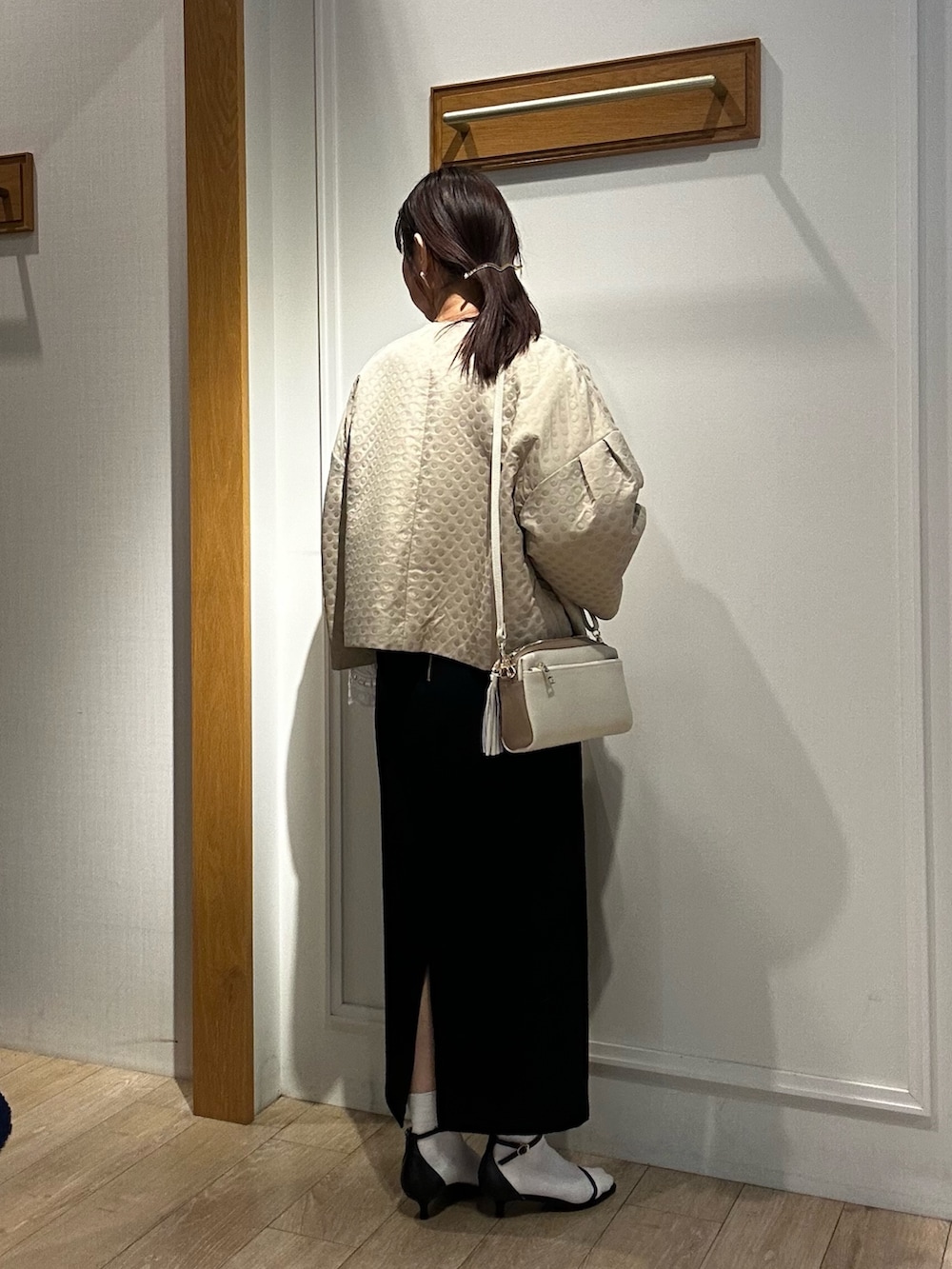 ホワイト系のショルダーバッグ、ホワイト系のシャツ/ブラウス、ベージュ系のブルゾンを着用したレディースの冬コーディネートの3枚目の写真