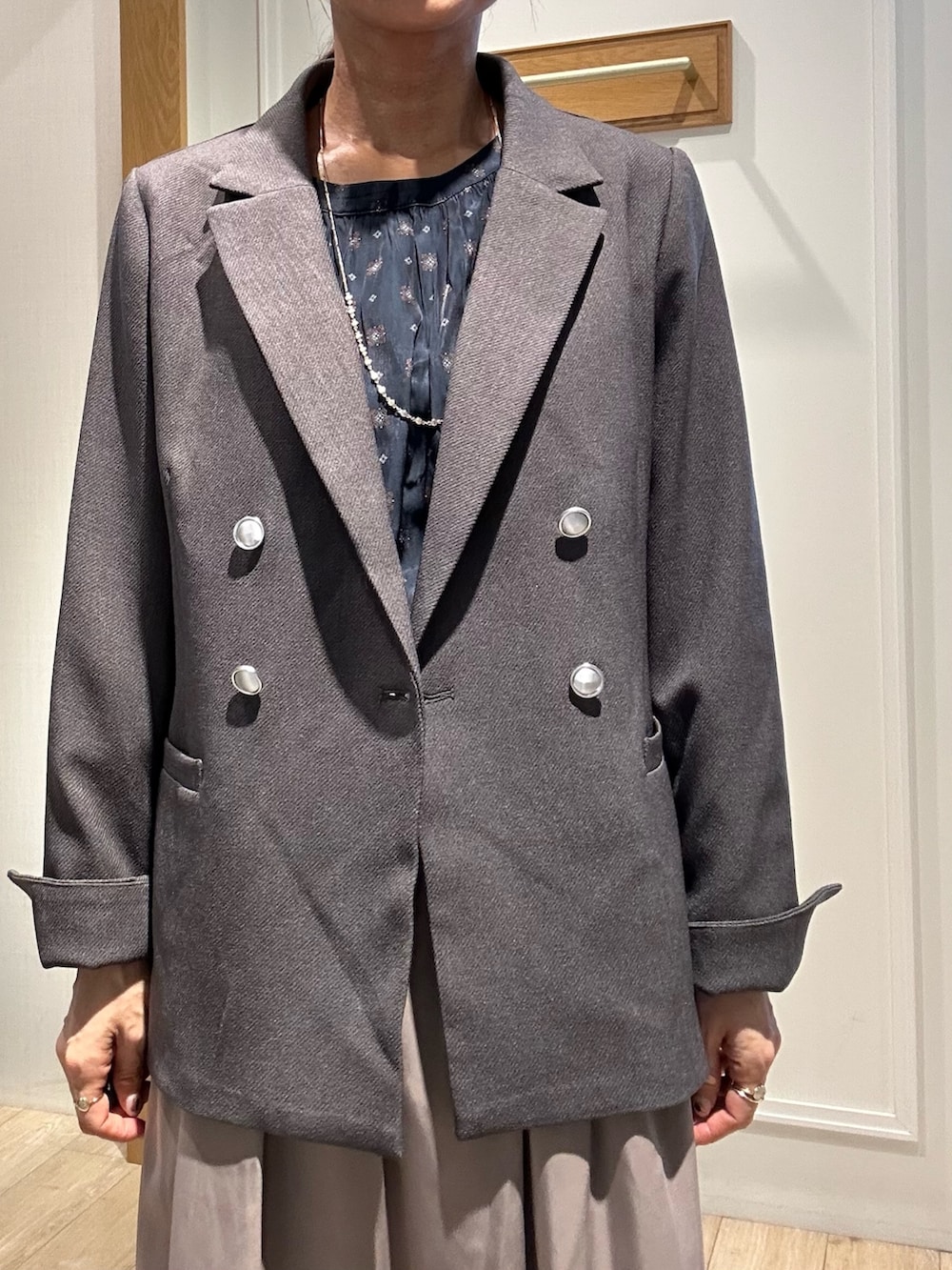 グレー系のテーラードジャケット、ブラウン系のスカート、ブルー系のシャツ/ブラウスを着用したレディースの秋コーディネートの6枚目の写真