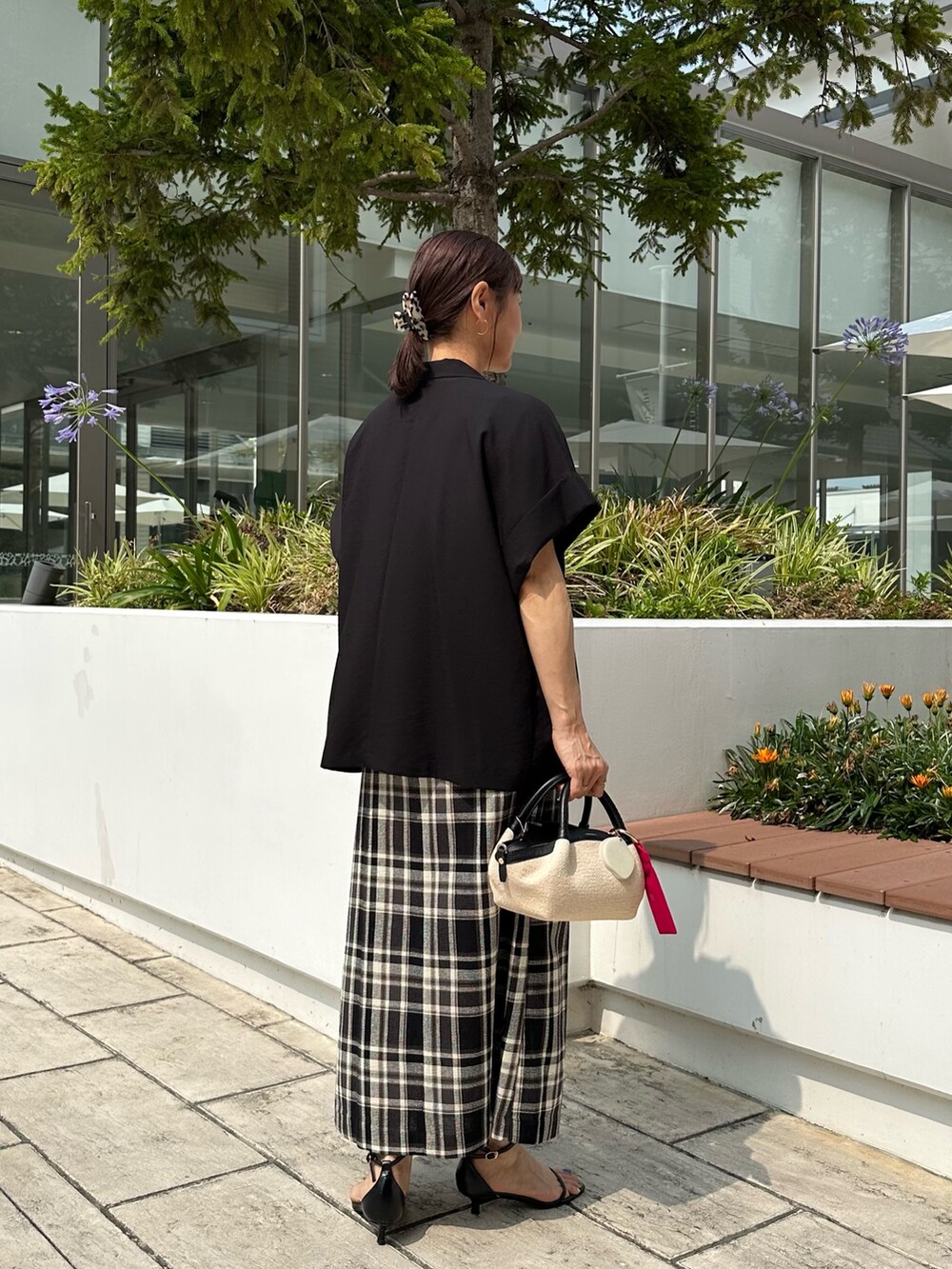 ブラック系のテーラードジャケット、ホワイト系のTシャツ/カットソー、ブラック系のバックパック/リュックを着用したレディースの夏コーディネートの4枚目の写真