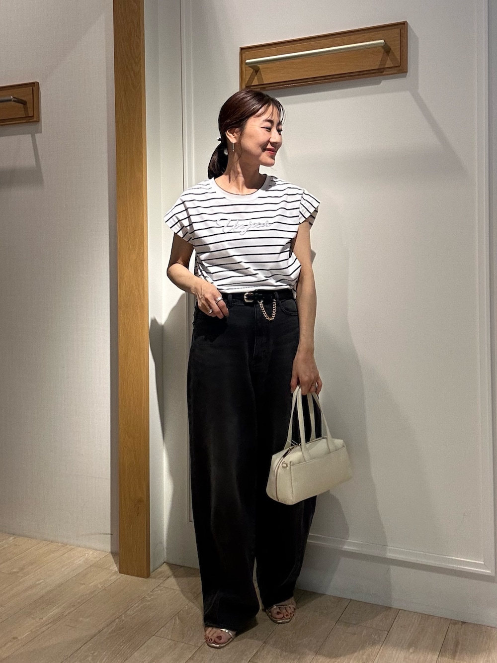 ホワイト系のTシャツ/カットソー、ブラック系のサンダル、ホワイト系のボストンバッグを着用したレディースの夏コーディネートの5枚目の写真