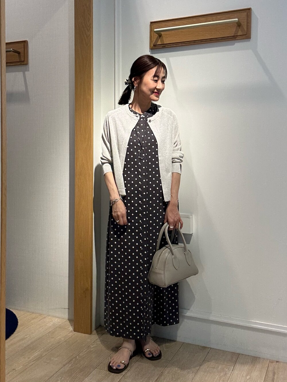 シルバー系のニット/セーター、グレー系のワンピース、ベージュ系のボストンバッグを着用したレディースの夏コーディネートの5枚目の写真