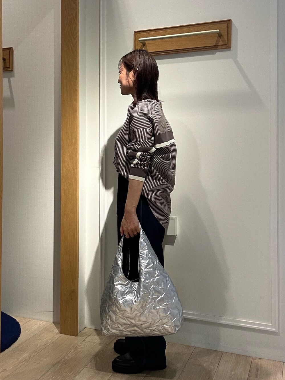 ブラウン系のシャツ/ブラウス、ブルー系のデニムパンツ、シルバー系のトートバッグを着用したレディースの秋コーディネートの2枚目の写真