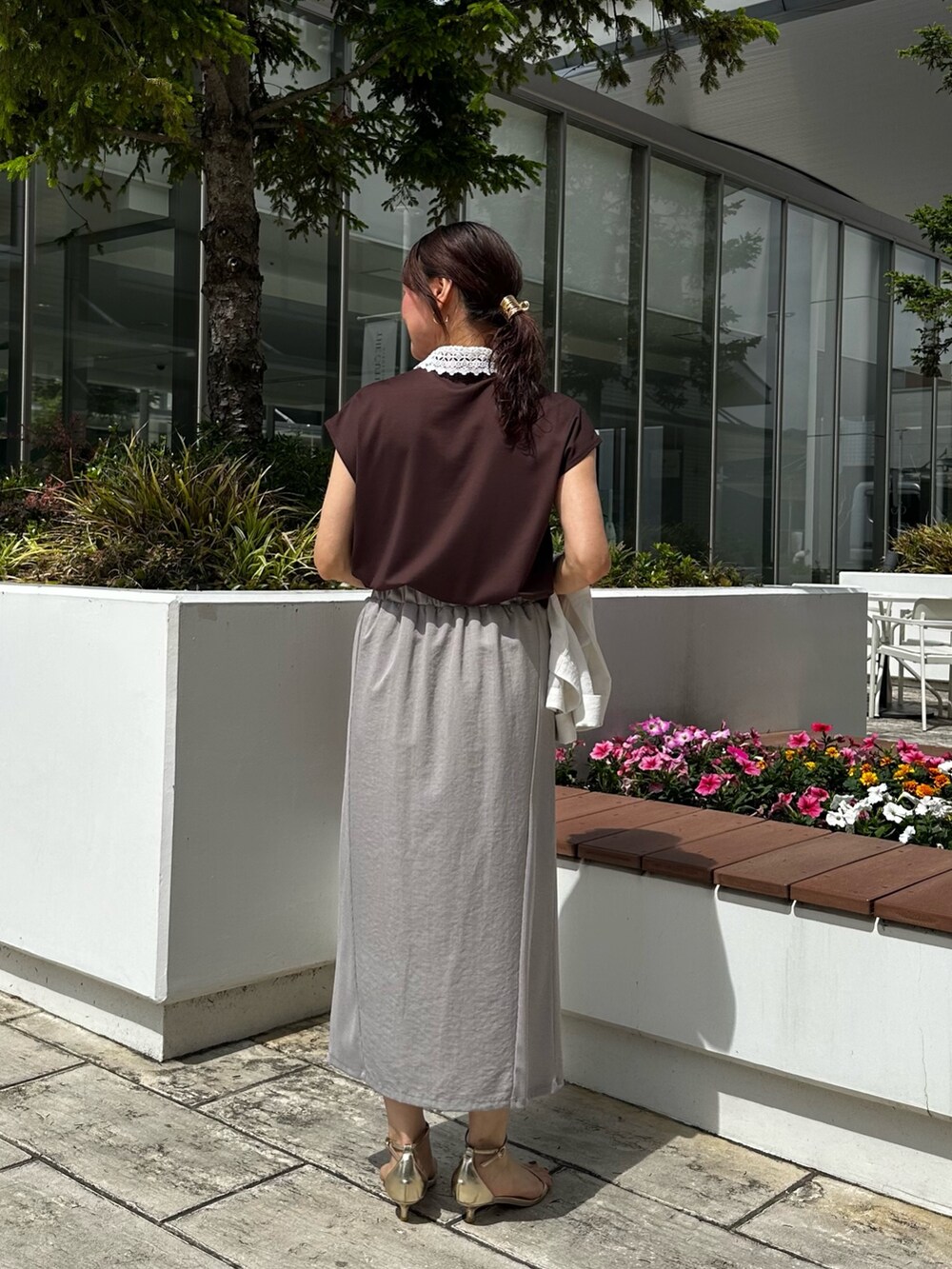 ホワイト系のノーカラージャケット、ブラウン系のTシャツ/カットソー、グレー系のスカートを着用したレディースの夏コーディネートの8枚目の写真