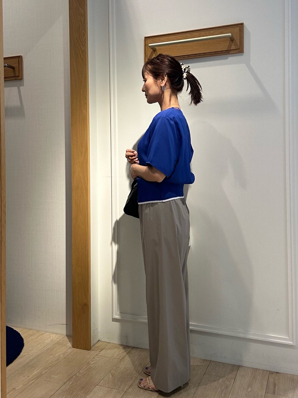 ブルー系のシャツ/ブラウス、ベージュ系のその他パンツ、ブラック系のボストンバッグを着用したレディースの夏コーディネートの2枚目の写真