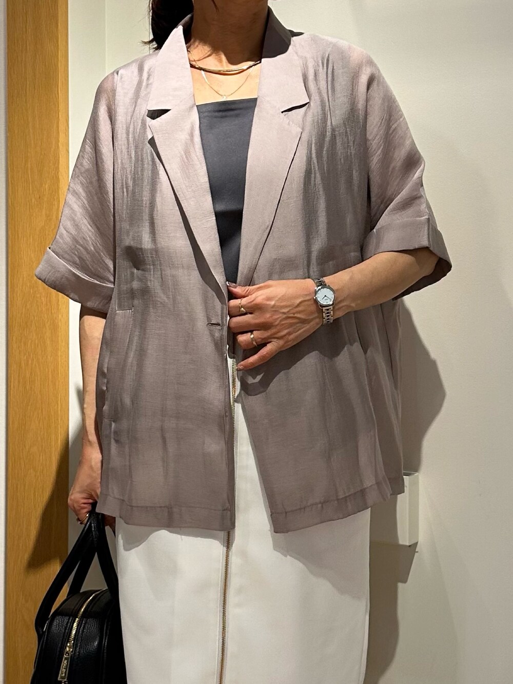 ブラック系のサンダル、グレー系のTシャツ/カットソー、ホワイト系のスカートを着用したレディースの夏コーディネートの6枚目の写真