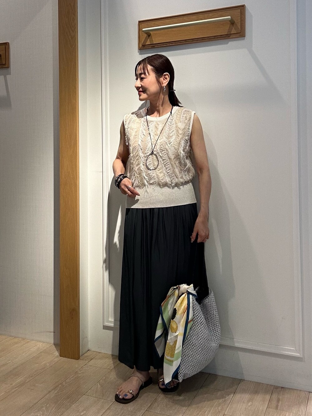 ベージュ系のニット/セーター、グレー系のその他パンツ、グレー系のショルダーバッグを着用したレディースの夏コーディネートの5枚目の写真