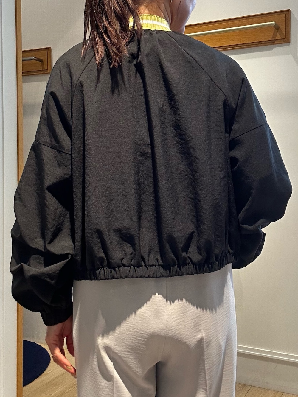 ベージュ系のその他パンツ、イエロー系のカーディガン/ボレロ、ブラック系のブルゾンを着用したレディースの春コーディネートの7枚目の写真