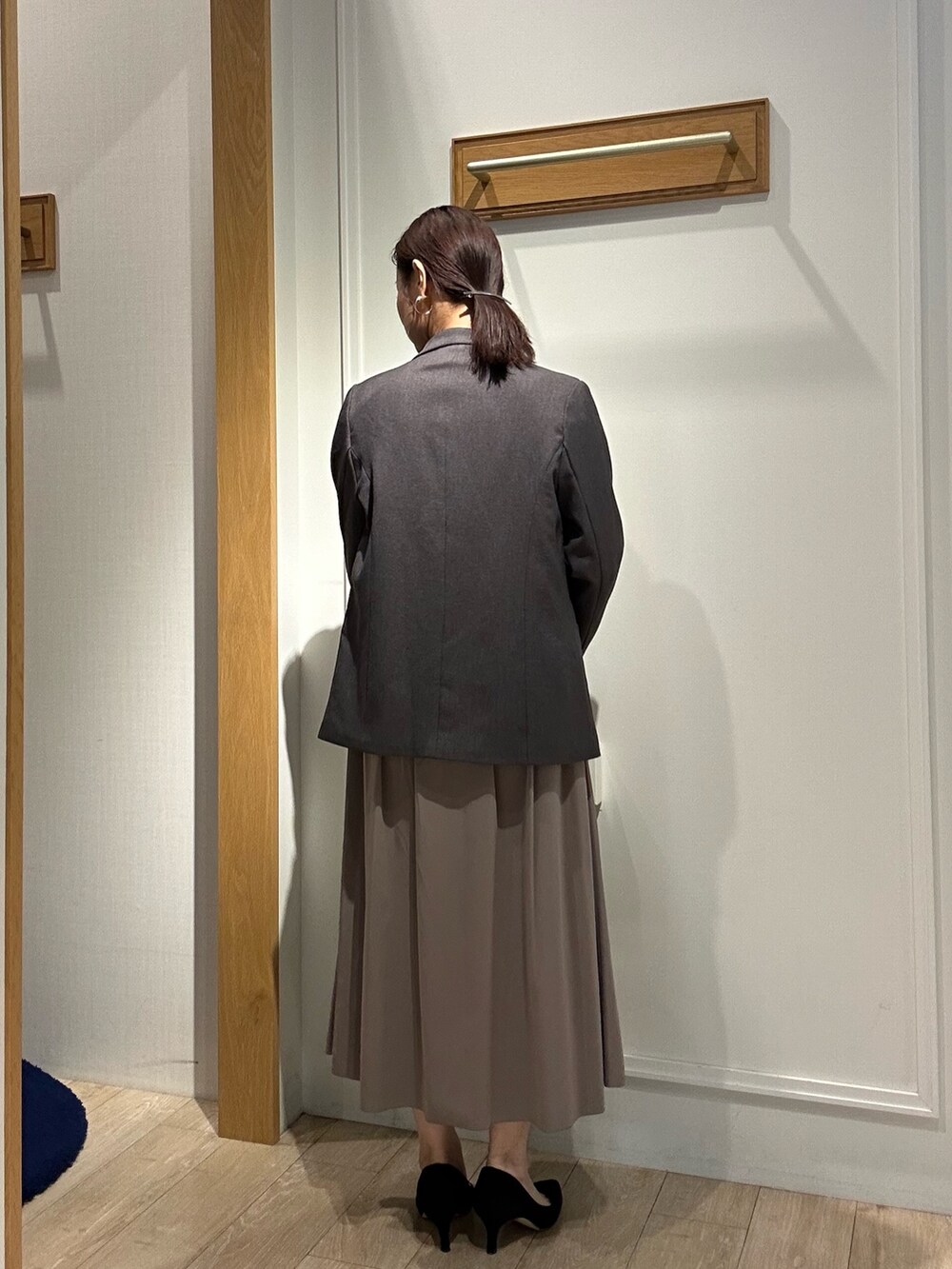 グレー系のテーラードジャケット、ブラウン系のスカート、ブルー系のシャツ/ブラウスを着用したレディースの秋コーディネートの3枚目の写真