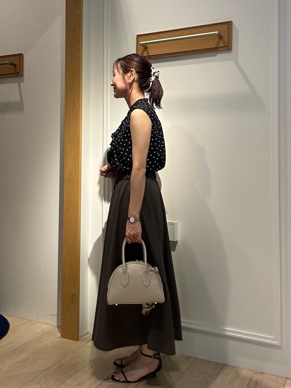 ブラック系のシャツ/ブラウス、グレー系のスカート、ベージュ系のボストンバッグを着用したレディースの夏コーディネートの2枚目の写真