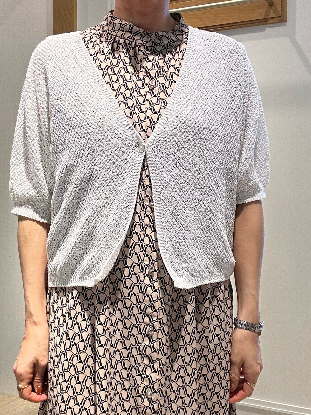 ベージュ系のワンピース、ホワイト系のカーディガン/ボレロ、ゴールド系のショルダーバッグを着用したレディースの春コーディネートの7枚目の写真