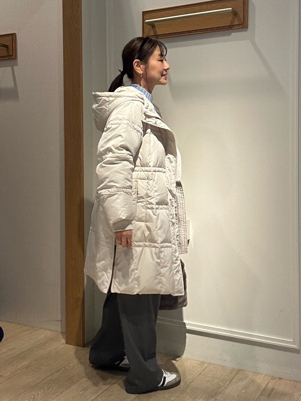 ベージュ系のダウンジャケット/コート、ブルー系のニット/セーターを着用したレディースの冬コーディネートの2枚目の写真