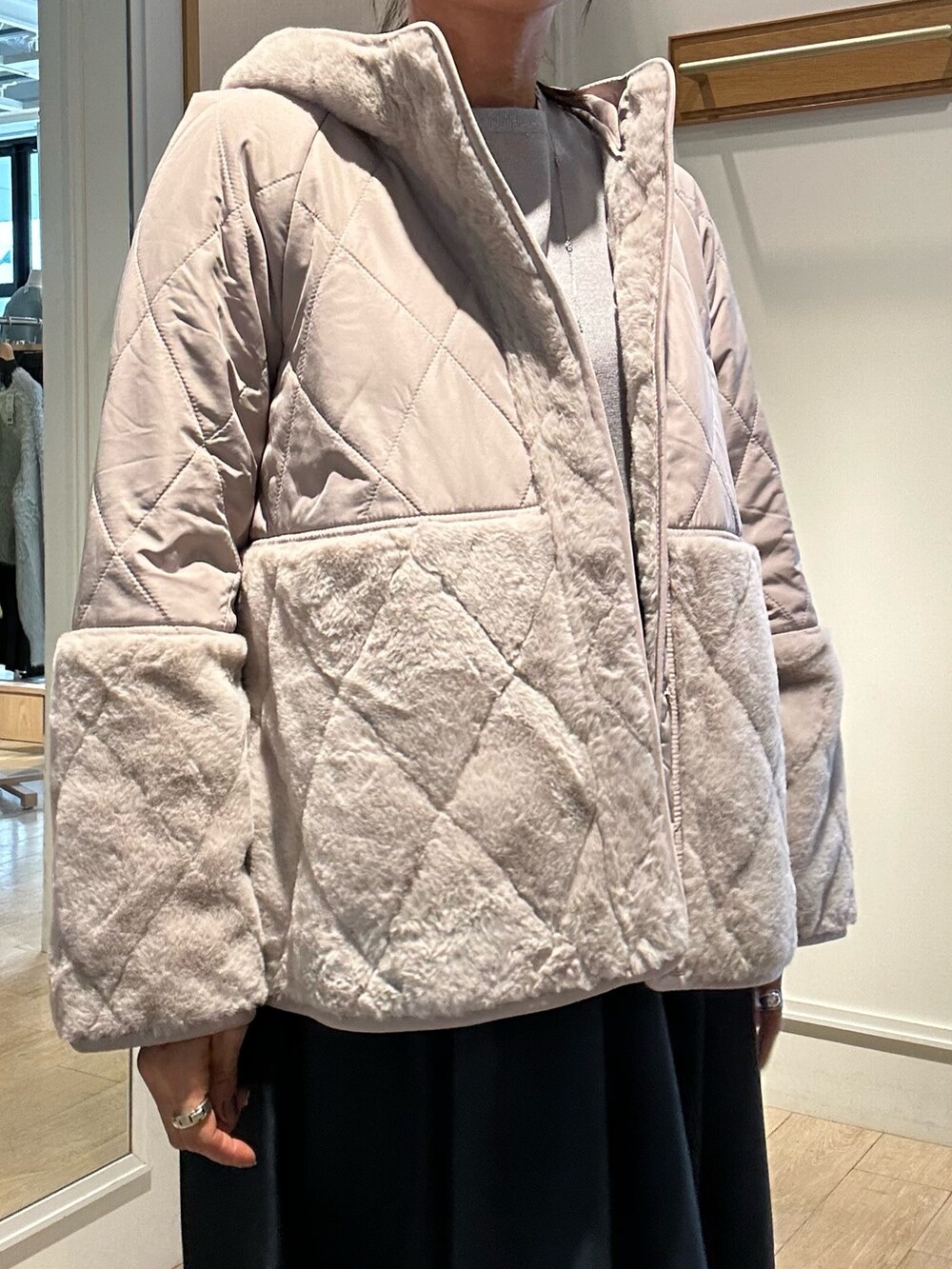 ベージュ系のブルゾン、グレー系のワンピースを着用したレディースの冬コーディネートの3枚目の写真